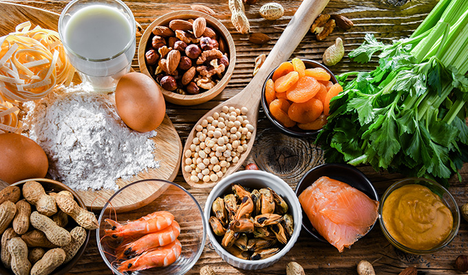 variety of fresh ingredients including flour eggs celery nuts dried fruits seafood and a glass of milk ideal for five ingredient recipes